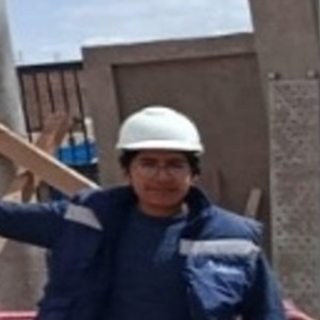 Jefe de logística y operaciones, con casco blanco y casaca azul, en una obra en construcción.